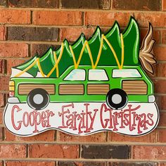 a green and white sign that says cooper family christmas on the side of a brick wall