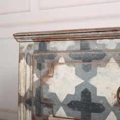 an old painted cabinet with a clock on it's front and side door knobs