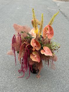 a bouquet of flowers is sitting on the ground in the middle of the street,