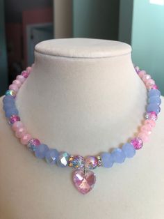 This aurora borealis pink heart charm choker stuns with pink and blue crackle glass beads, light blue aurora borealis faceted glass beads, and light pink faceted glass beads. This piece is exquisite in its ability to reflect light and color. Pink Crystal Necklace With Heart Charm, Pink Heart Charm Choker Necklace, Pink Crystal Choker Necklace As A Gift, Pink Crystal Choker Necklace For Gift, Pink Crystal Necklace With Faceted Beads, Pink Crystal Beaded Necklace For Gift, Pink Heart Beads Choker Jewelry, Pink Aurora Borealis, Pink Aurora