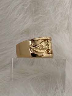 a gold ring sitting on top of a clear shelf