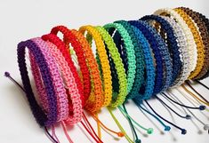 there are many different colors of bracelets on the table