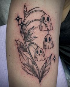 a tattoo with skulls and leaves in the shape of a heart