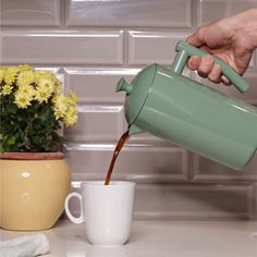 a person pours coffee into a mug