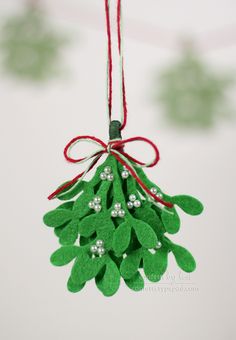 a green ornament hanging from a red string