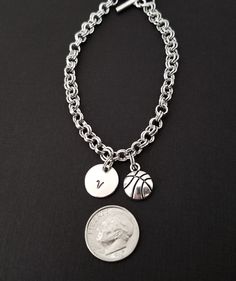 "Personalized Antique Silver Basketball Bracelet! A detailed basketball charm on a lovely chain bracelet makes the perfect gift for you or your favorite basketball player. The basketball bracelet charm is made from zinc alloy and measures 13 x 10 mm. The bracelet is high quality zinc alloy and measures 8.5\". The basketball player bracelet can be personalized with a .5\" silver plated disc stamped with the initial of your choice. The charm and initial disc are connected to the bracelet with stur Sporty Personalized Bracelets For Sports Events, Personalized Adjustable Sports Jewelry, Sporty Personalized Name Bracelet As A Gift, Adjustable Sporty Silver Bracelets, Casual Hoop Jewelry Gift, Casual Hoop Jewelry For Gift, Personalized Silver Charm Bracelet Casual Style, Personalized Silver Charm Bracelet, Casual Personalized Silver Charm Bracelet