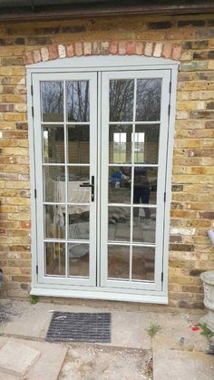 an image of a patio with french doors and brick wall in the back ground area