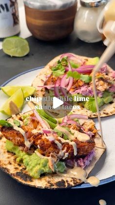 two flatbreads with chicken, lettuce and red onion on them sitting on a plate