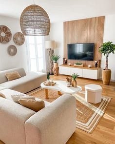 a living room filled with furniture and a flat screen tv on top of a wooden wall