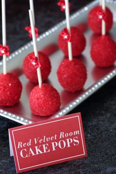 red velvet room cake pops are displayed on a tray with a sign that reads, red velvet room cake pops