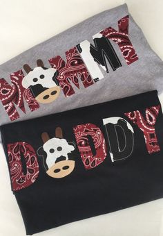 two t - shirts with the words daddy and baby printed on them, one is grey and the other is red