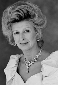 an old black and white photo of a woman in a dress with pearls on her neck