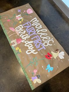 a brown paper bag with flowers and fairy characters on it sitting on top of a table