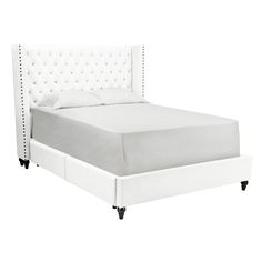 a white bed with tufted upholstered headboard and foot board, viewed from the side