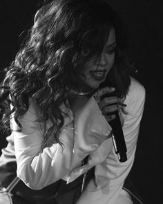 a black and white photo of a woman holding a microphone