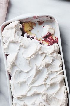 a white dish filled with whipped cream on top of a table