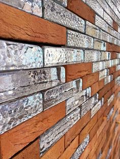 a close up view of a brick wall made out of wood and glass tiles,