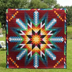 a colorful quilt is hanging in the grass