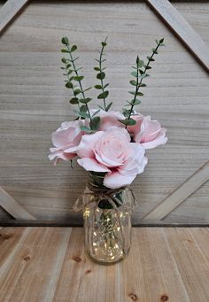 a vase filled with pink flowers on top of a wooden table