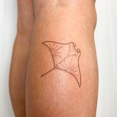 a woman's leg with a tattoo on it that is shaped like a stingfish