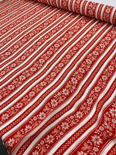 a red and white blanket sitting on top of a bed