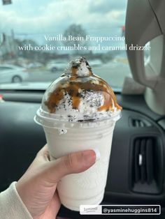 a person holding up a cup with ice cream and caramel drizzle on it