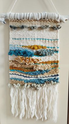 a wall hanging made out of yarn and tassels