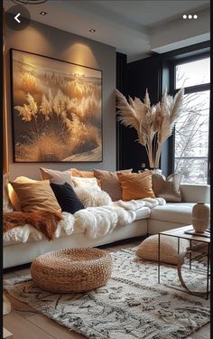 a living room filled with lots of furniture and pillows on top of a white rug