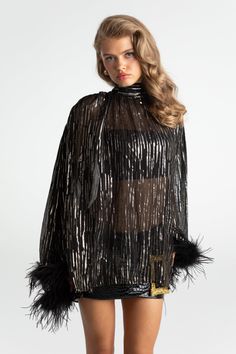 Adorn yourself in luxurious feathers that make you feel fearless and free. The Keira Feather Top is everything you've been dreaming of for this season's fashion. The shirt is made of gorgeous silky fabric that is woven and elegant. The neckline is designed to tightened or worn loose with ribbon, and the cuffs are ever-so fluffy with feathers. Make the ultimate statement. Silk material Ribbon included Feather cuffs Dry clean only Luxury Feather Trim Evening Tops, Fitted Black Outerwear With Feather Trim, Luxury Women's Feathered Outerwear, Chic Black Top With Feather Trim, Luxury Long Sleeve Outerwear With Feather Trim, Feather Cuffs, Feather Top, Feather Tops, Silky Fabric