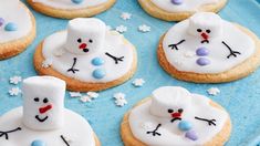 snowman cookies decorated with marshmallows and frosting on a blue plate