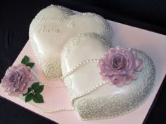 a heart shaped cake with two roses on the top and one in the shape of a heart