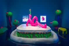 a birthday cake with the word love on it in front of other cakes and decorations