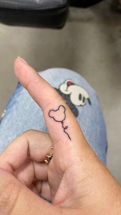 a person's finger with a small heart on it and a dog drawn on the thumb