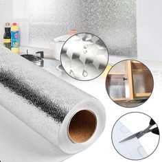 a roll of silver metallic foil next to a sink and counter top with scissors on it