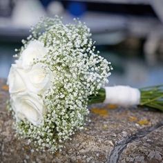 a bridal bouquet sitting on top of a rock