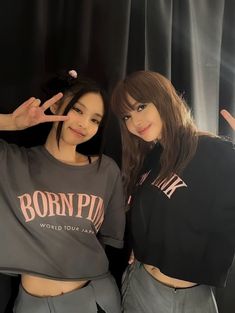 two young women posing for the camera with their hands in the air and one holding her hand up