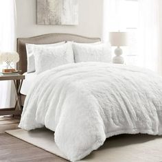 the comforter is white in color and has fluffy fur on it's edges