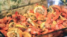 a glass dish filled with shrimp and lemon slices