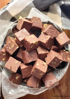 a bowl filled with pieces of chocolate sitting on top of a table