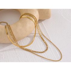 Channel your inner fashion icon with the Cascading Trio Necklace Set. This versatile set features three separate chains in varying lengths, each crafted from high-quality, tarnish-resistant stainless steel with a gleaming gold plating. The cascading design creates a beautiful layered effect, allowing you to personalize your look and add a touch of modern elegance to any outfit. Plus, the waterproof construction ensures you can wear it worry-free. Material: Stainless Steel with Gold Plating Three Separate Adjustable Chains:Necklace 1: 13.5" + 2" extensionNecklace 2: 16" + 2" extensionNecklace 3: 18" + 2" extension Waterproof & Tarnish-Resistant Mix and match the chains or wear them all together for a truly captivating look! Gold Layered Snake Chain Necklace, Modern Double Strand Gold Chain Necklace, Modern Gold Chain Necklace For Layering, Modern Gold Multi-strand Jewelry, Modern Multi-strand Gold Jewelry, Gold Multi-strand Metal Chain Necklace, Gold-tone Metal Layered Necklace With Double Chain, Modern Gold Layered Necklace With Delicate Chain, Gold-tone Double Chain Metal Necklace