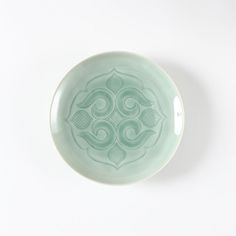 a green plate sitting on top of a white table