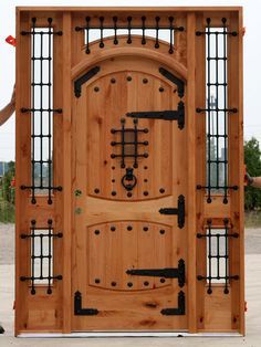 the wooden door is made from wood and has metal bars on each side, as well as