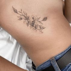 a woman's stomach with flowers and leaves on it