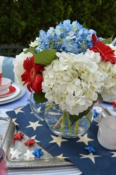 a patriotic table setting with red, white and blue flowers