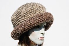 "Styl: warm winter cloche hat features a with a wide turn back brim.The perfect hat for autumn and winter days. Material: a mix of yarns of different structure and color. 20% wool, 80% acrylic Color:beige color hat on this auction but you will find other color options on my auctions.You can also compose your color set. Characteristics hat:chunky,soft,warm,unique Size:Head Circumference: 23\" - 24\" Height: 9\" A chunky, winter women's crochet hat.This hat is very elegant. Made from yarn of highe Brown Knit Beanie, Outdoor Crochet Hat Made Of Yarn, Fall Cable Knit Hat, Chunky Knit Wool Hat For Fall, Winter Hand Knitted Cloche Hat, Winter Knitted Brimmed Cloche Hat, Hand Knitted Adjustable Cloche Hat For Winter, Knitted Cloche Hat With Curved Brim For Winter, Adjustable Hand Knitted Cloche Hat For Winter