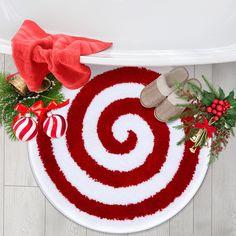 a pair of slippers sitting on top of a red and white rug next to christmas decorations