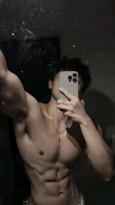 a shirtless man taking a selfie in the mirror with his cell phone up to his face