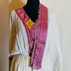 Ethiopian And Eritrean Traditional Dress (Habesha Kemis)Garment Is Predominantly White With Subtle Stripes, Featuring Pink And Black Embroidery Along The Edges And Neckline. It Includes A Draped Shawl Or Wrap With Similar Embroidery, Creating A Cohesive Look. This Type Of Attire Is Often Associated With Traditional Clothing From Certain Cultures, Possibly Ethiopian Or Eritrean, As Suggested By The Woven Baskets Placed Beside 100% Gorgeous Dress Any Ceremony. Traditional White V-neck Dress, White V-neck Kaftan For Festive Occasions, Festive White Dress With Woven Motifs, White Bohemian Kurta For Festivals, White Festive Kaftan For Spring, White Bohemian Kaftan For Festive Occasions, White Maxi Length Kaftan For Festive Occasions, White Tunic Kurta For Festive Occasions, White Festive Spring Kaftan