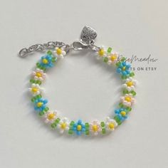 "Handmade Beaded Bracelet  ✿ Made with glass seed beads and metal accents ✿ Sky blue, yellow, milky white, light pink, and matte lime green ✿ The bracelet has 1.5\" of extension chain" White Round Beaded Friendship Bracelets For Spring, White Spring Jewelry For Friendship, Handmade Beaded Bracelets For Friendship In Spring, Handmade White Beaded Bracelets For Spring, Spring Blue Beaded Bracelets, White Spring Jewelry With Tiny Beads, Spring White Jewelry With Tiny Beads, Blue Spring Jewelry For Friendship, Spring Friendship Blue Jewelry