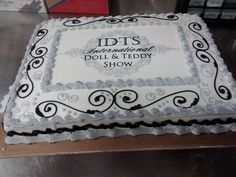 a white and black cake with the words idts on it's side sitting on a table